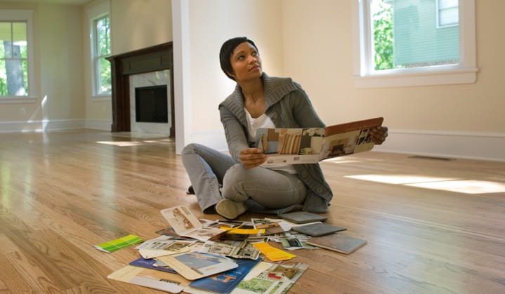 Persona revisando colores de pintura en la sala de estar gracias a las opciones de crédito con garantía hipotecaria de BOK.